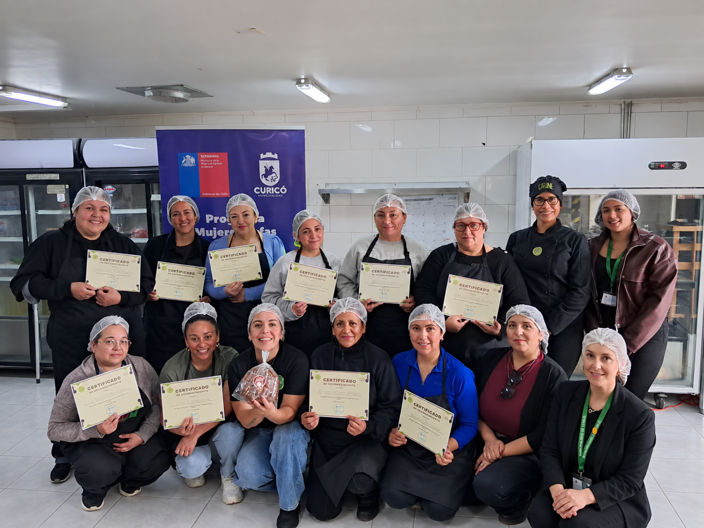 Grupo de mujeres emprendedoras sosteniendo sus certificados de reconocimiento tras un taller de cocina profesional de Cafuné Academy